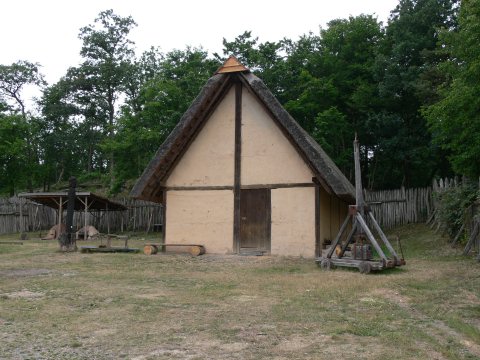 Ein Haus mit Gerätschaften und Bank.