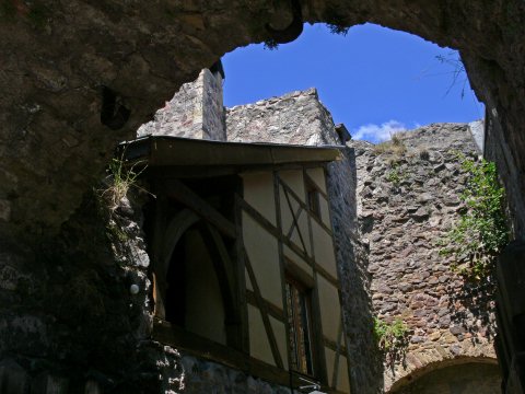 Fachwerk lehnt am dicken Mauerwerk.